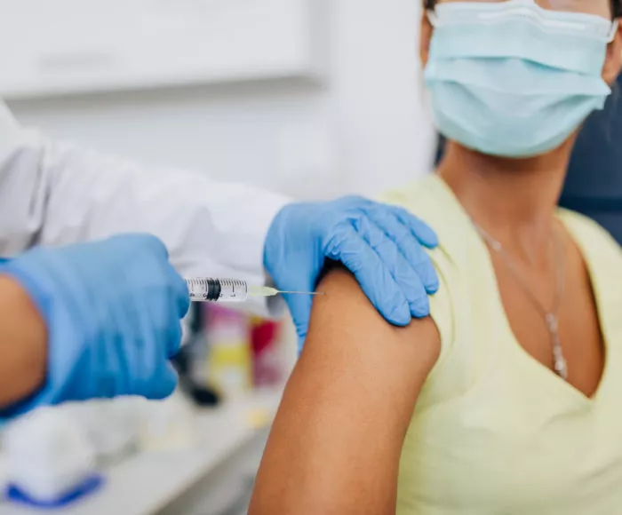 Female,Doctor,Or,Nurse,Giving,Shot,Or,Vaccine,To,A
